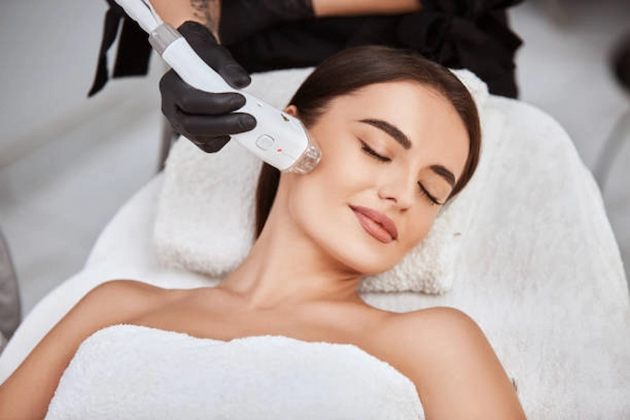 Skilled professional performing laser facial treatment.