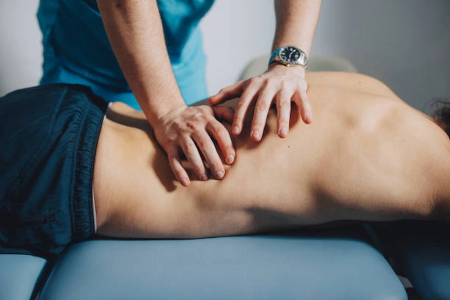 Therapist assisting patient with back pain relief.