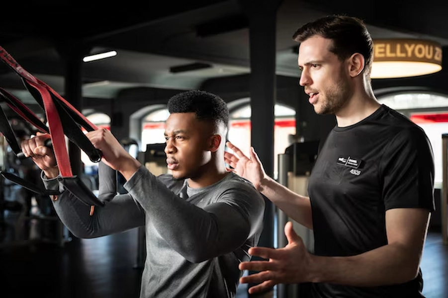 Strength coach guiding a client in training
