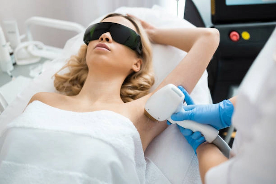 Client undergoing underarm laser hair removal treatment.